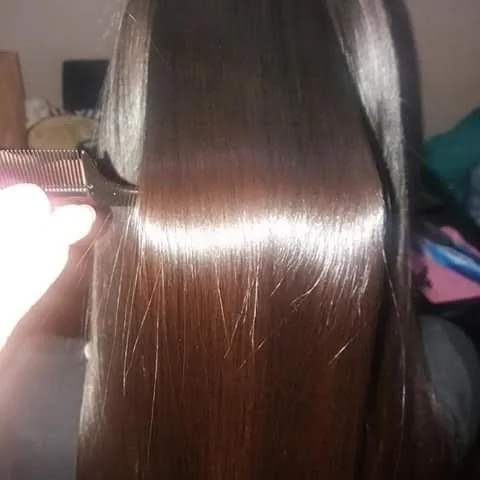 Un peine atraviesa cabello castaño lacio sin encontrar nudos